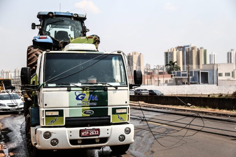Caminhão carregando trator derruba 6 postes de energia e deixa idosa presa em carro na Capital