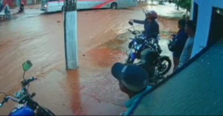 Após mulher cair com moto, marido questiona condutor de ônibus que a fez passar na enxurrada
