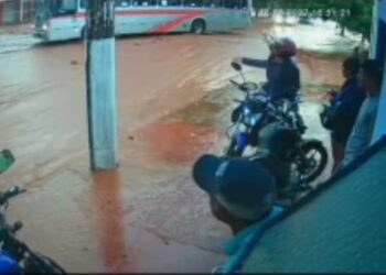 Após mulher cair com moto, marido questiona condutor de ônibus que a fez passar na enxurrada