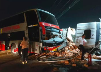 Em colisão, carga de tijolos de caminhão vai parar dentro de ônibus e fere duas pessoas