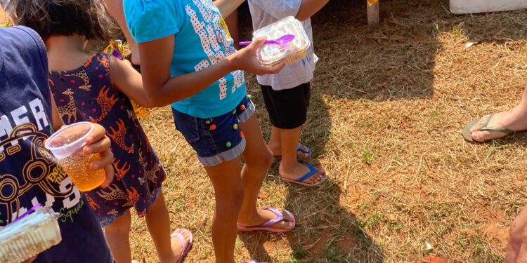 Crianças de comunidade recebem em ação hambúrgueres, doces e bolos de porte, na Capital