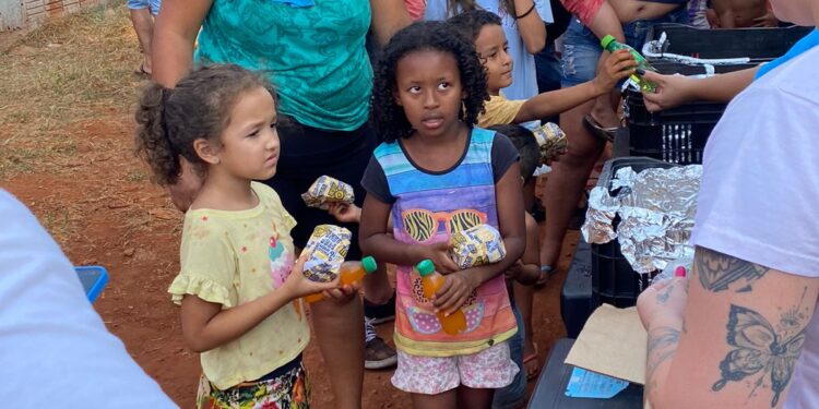 Crianças de comunidade recebem em ação hambúrgueres, doces e bolos de porte, na Capital