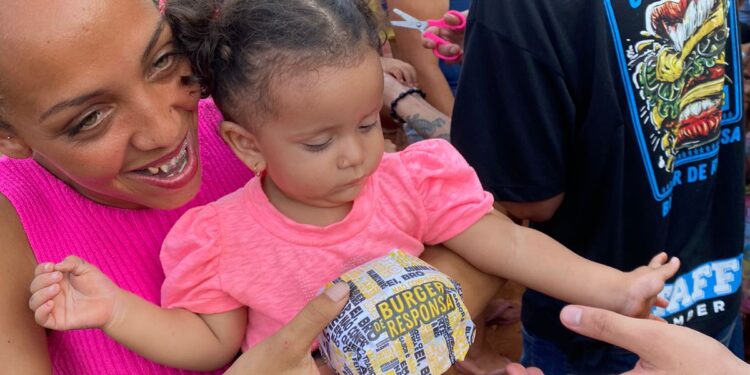 Crianças de comunidade recebem em ação hambúrgueres, doces e bolos de porte, na Capital